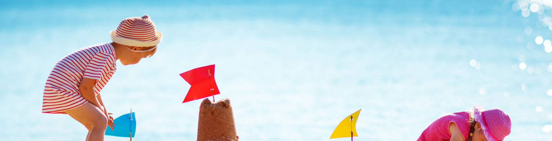 Kinder bauen Sandburg am Strand im Familienurlaub in Ägypten