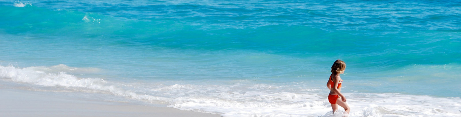 Kind badet im Meer im Ibiza Familienurlaub