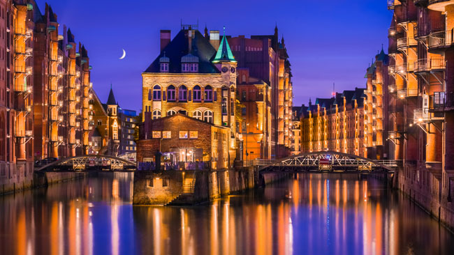 Blick auf das Wasserschloss in der Speicherstadt von Hamburg am Abend